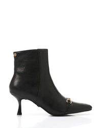Black ankle boot with a gold buckle on a white background